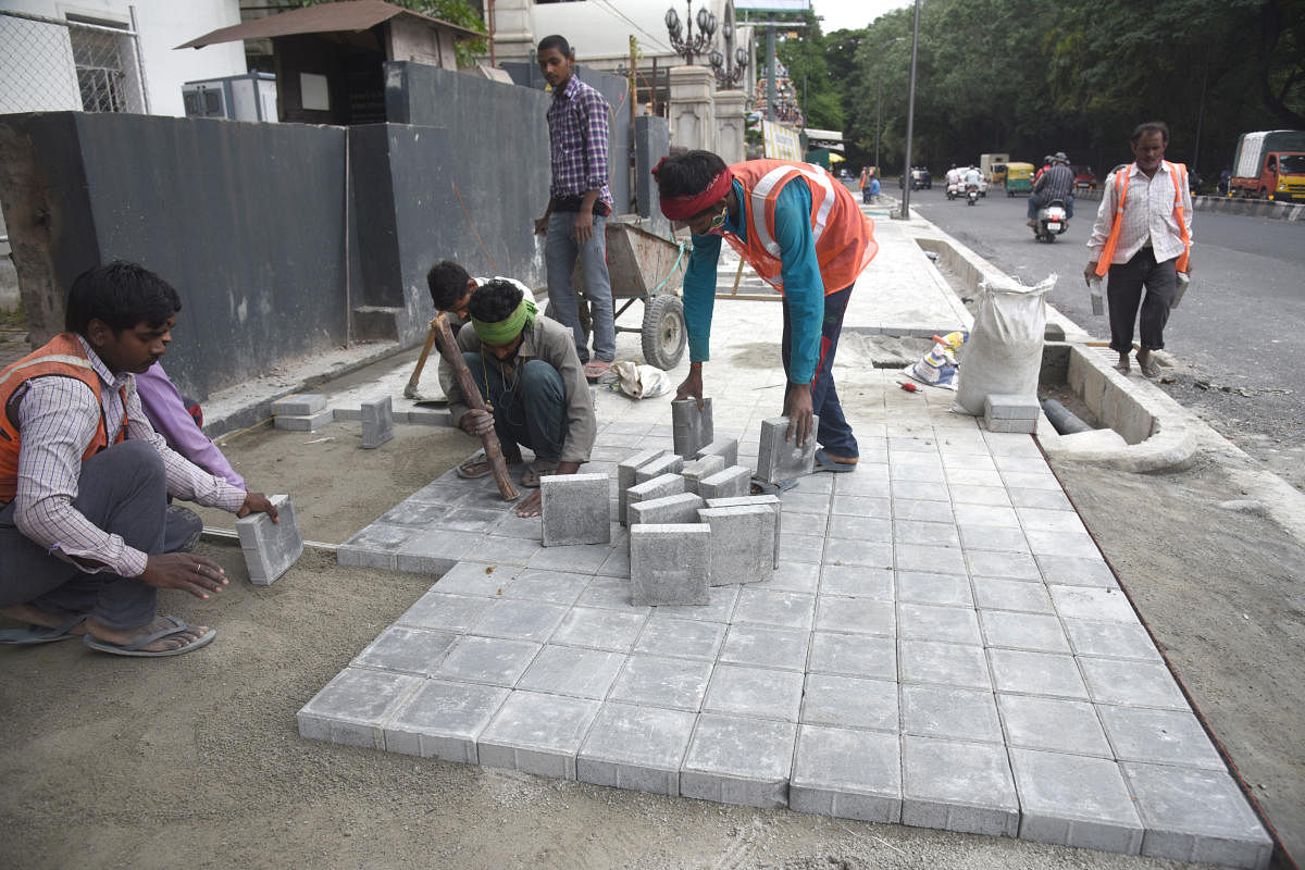Workers redo the pavement of Kasturba Road under the Smart Cities Mission project on Saturday. Credit: DH Photo/S K DINESH
