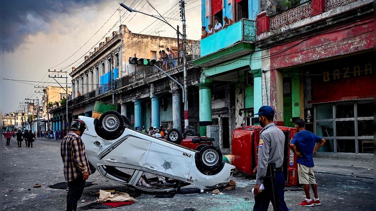 Police cars are seen overturned in the street in the framework of a demonstration against Cuban President Miguel Diaz-Canel in Havana. Credit: AFP File Photo