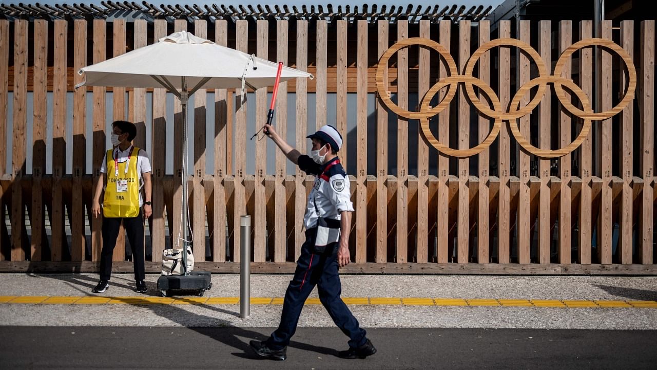 A staff member guides a taxi at one of the entrances at the Olympic and Paralympic Village in Tokyo on July 15, 2021, ahead of the 2020 Tokyo Olympic Games which begins on July 23. Credit: AFP Photo