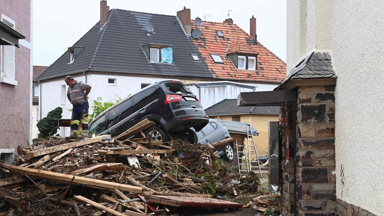 A man stands next to piled up debris and damaged cars in a street in Bad Neuenahr-Ahrweiler, western Germany. Credit: AFP Photo
