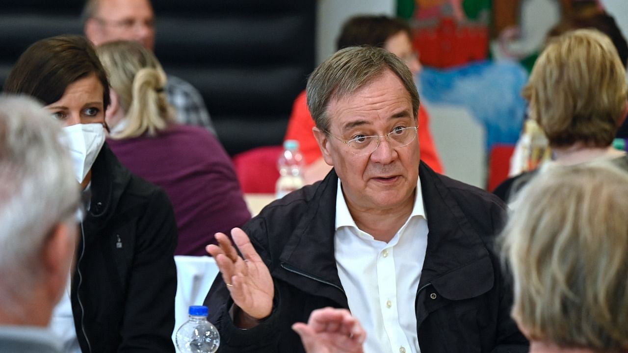 North Rhine-Westphalia's state premier and Christian Democratic Union (CDU) leader Armin Laschet speaks with a woman as he visits the emergency accommodations for flood victims set up at the Ville Gymnasium school in Erftstadt, western Germany. Credit: AFP Photo