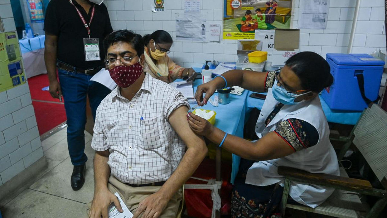 A health worker inoculates a man with a dose of vaccine at a health centre in New Delhi. Credit: AFP Photo