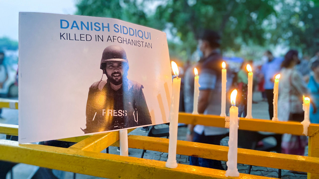Candles are seen lit next to a photograph of Reuters journalist Danish Siddiqui. Credit: Reuters Photo