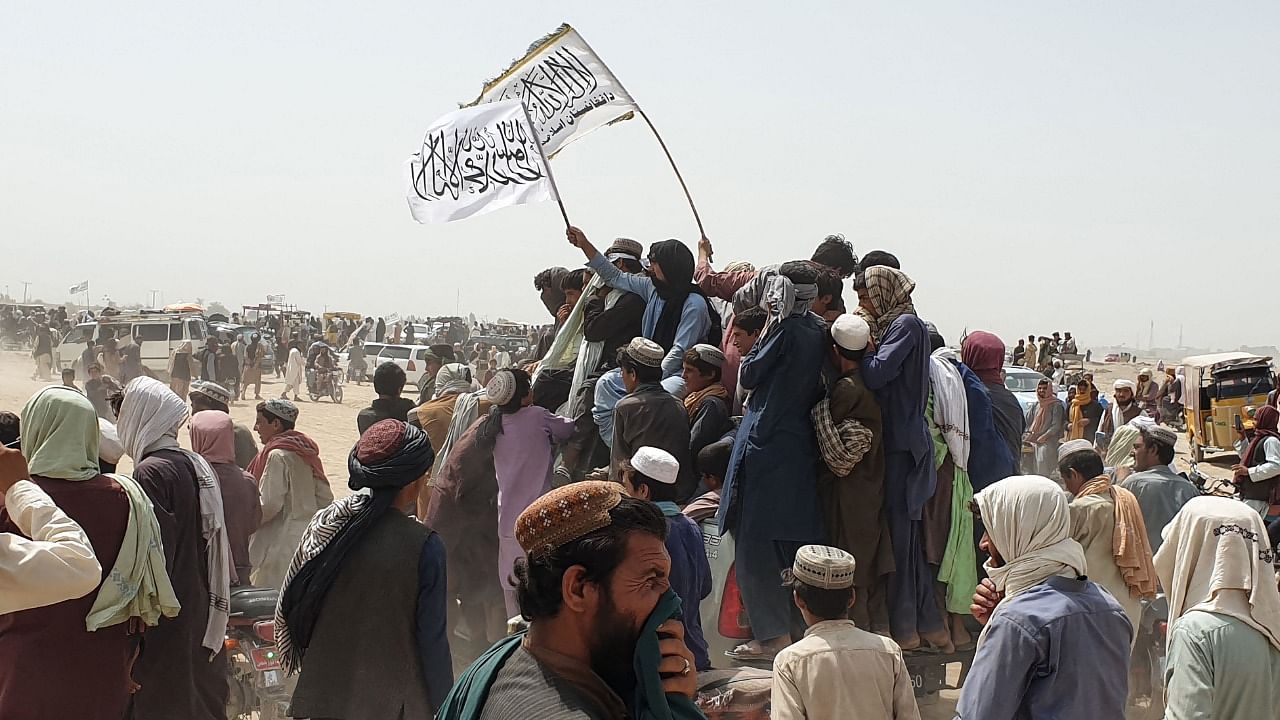 People wave Taliban flags as they drive through the Pakistani border town of Chaman. Credit: AFP File Photo