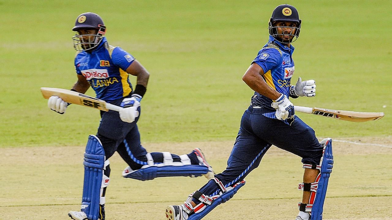 Sri Lanka's Charith Asalanka (L) and captain Dasun Shanaka run between the wickets during the first One Day International. Credit: AFP File Photo