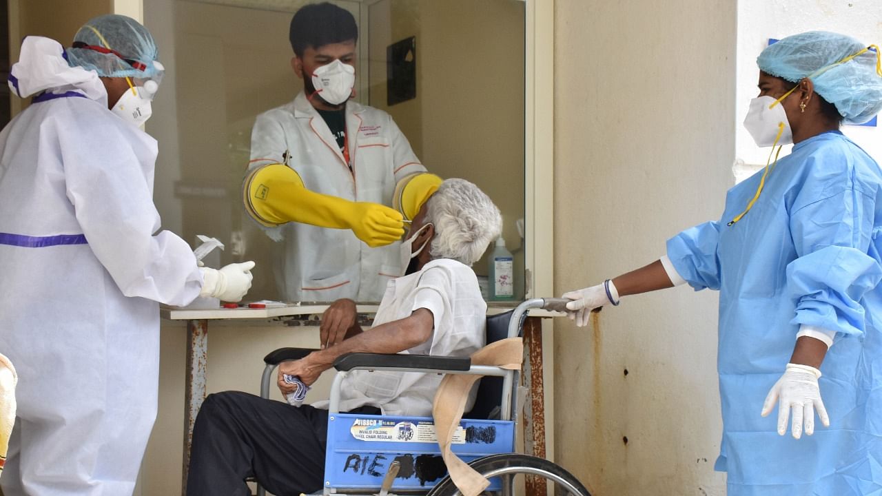 A health worker collects a sample for a Covid-19 test in MS Ramaiah Hospital. Credit: DH File Photo
