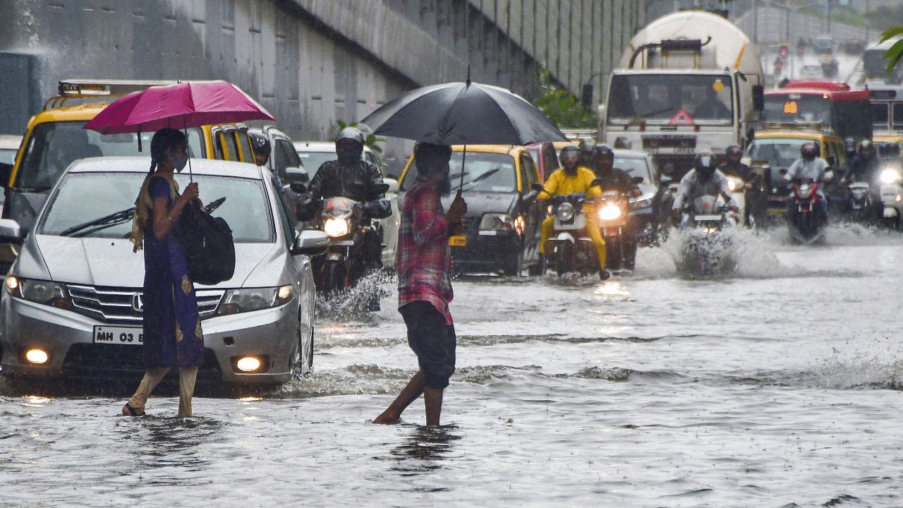 Along the Western Express Highway, people could be seen walking in knee-deep waters. Credit: PTI Photo