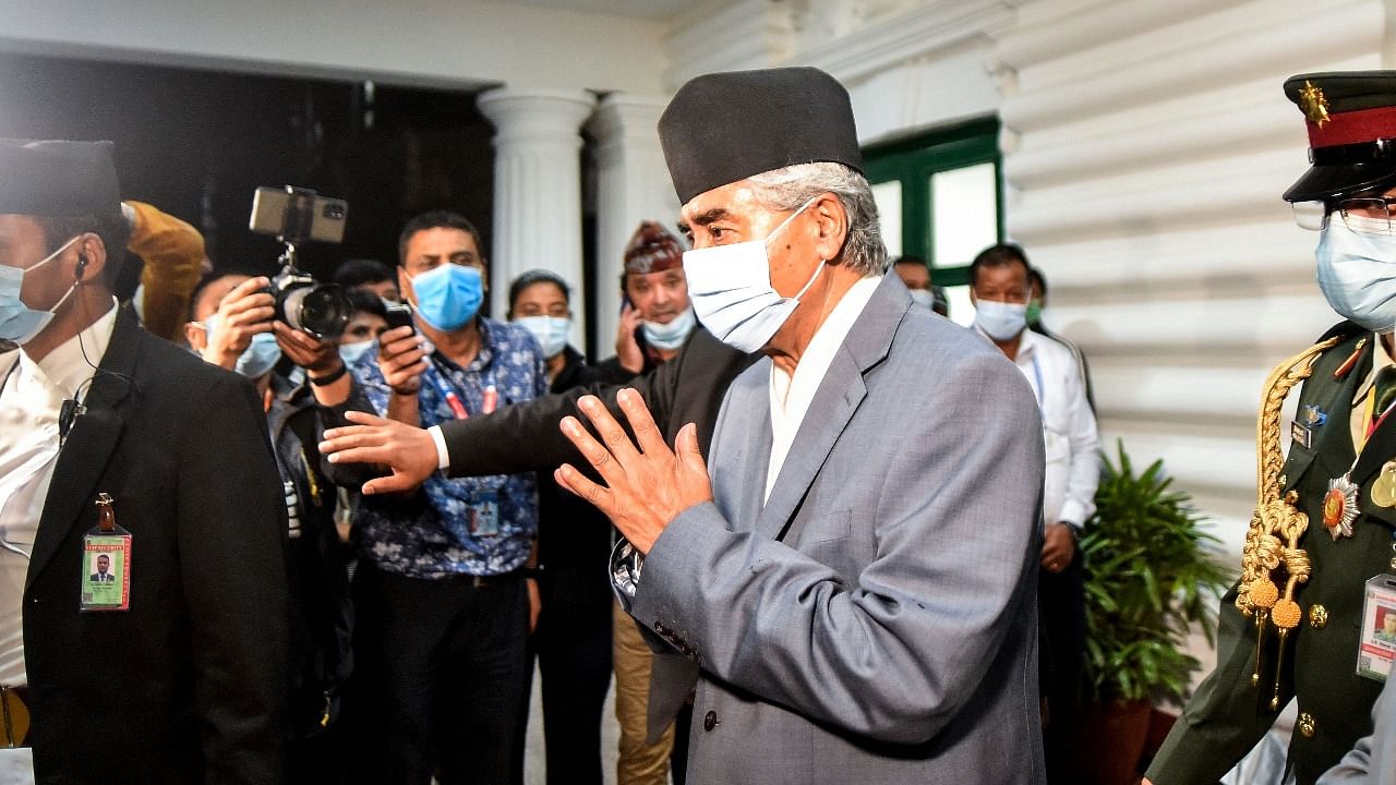 Newly appointed Prime Minister and President of Nepali Congress party Sher Bahadur Deuba (C) greets as he arrives at Singha Durbar office complex in Kathmandu. Credit: AFP Photo