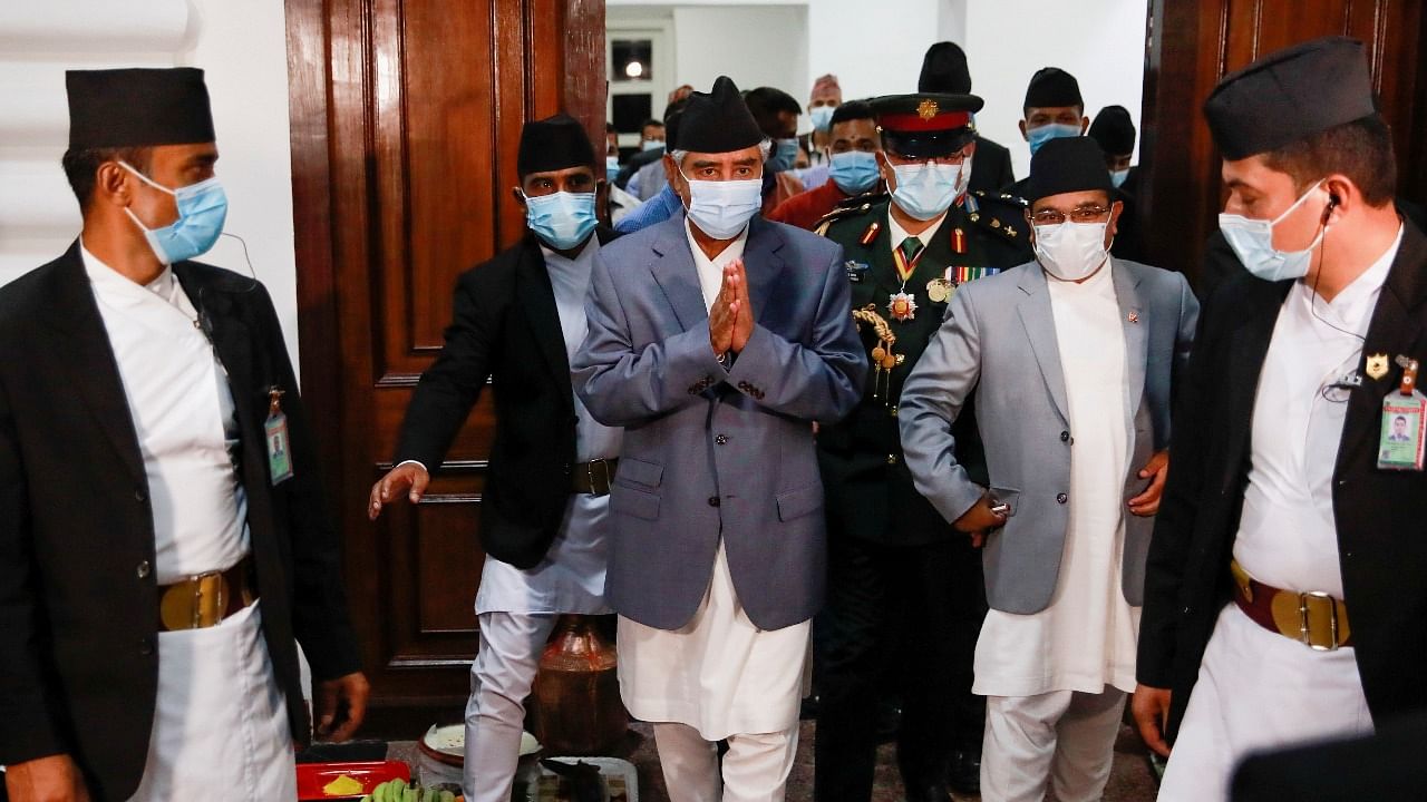 Newly appointed Prime Minister Sher Bahadur Deuba, wearing a face mask, walks after formally assuming office at Singha Durbar office complex that houses the Prime Minister's office and other ministries, in Kathmandu. Credit: Reuters photo