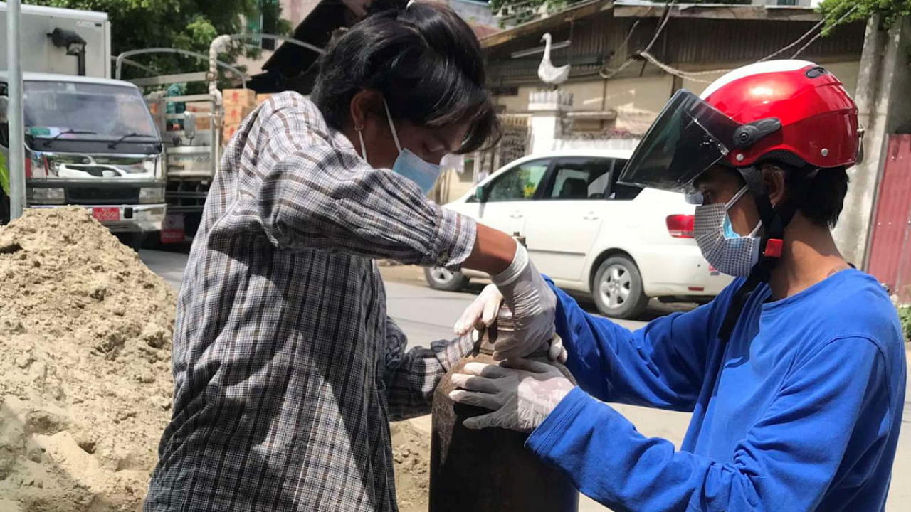 A volunteer fills an oxygen tank as coronavirus disease (COVID-19) cases surge in Mandalay, Myanmar. Credit: Reuters Photo