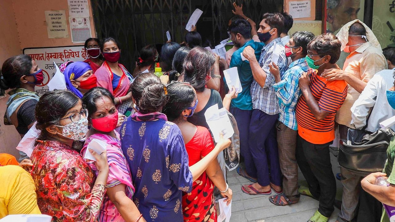 People, flout social distancing norms as they wait to receive a dose of COVID-19 vaccine at a government dispensary in Jaipur, Saturday, July 17, 2021. Credit: PTI Photo