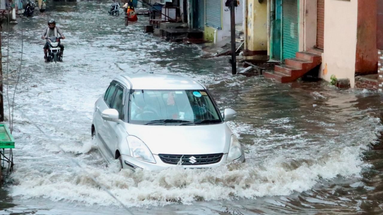Vehicles wade through a waterlogged street during heavy rain in Aligarh. Credit: PTI File Photo