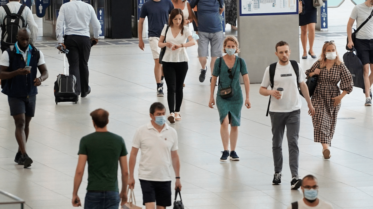 Commuters with and without facemasks arrive at Waterloo station in London. Credit: AFP Photo