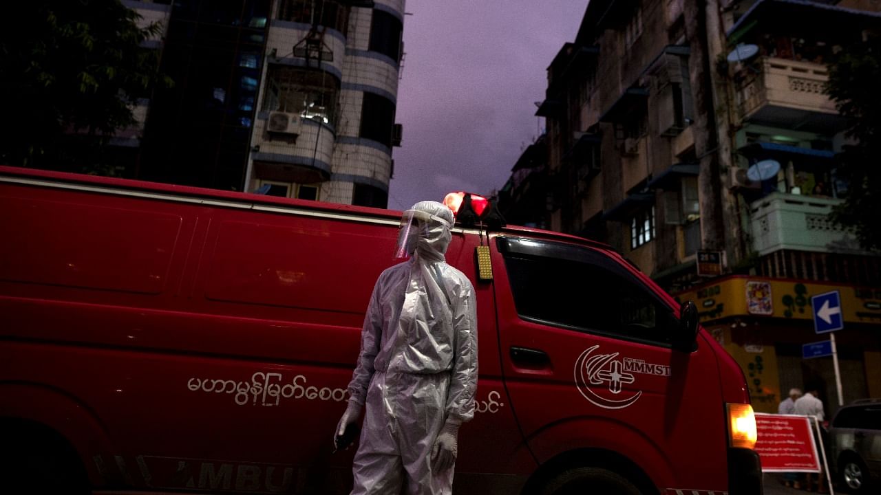 A medical staff wearing a protective suit stands near an ambulance, amid the outbreak of coronavirus, in Yangon, Myanmar. Credit: Reuters Photo