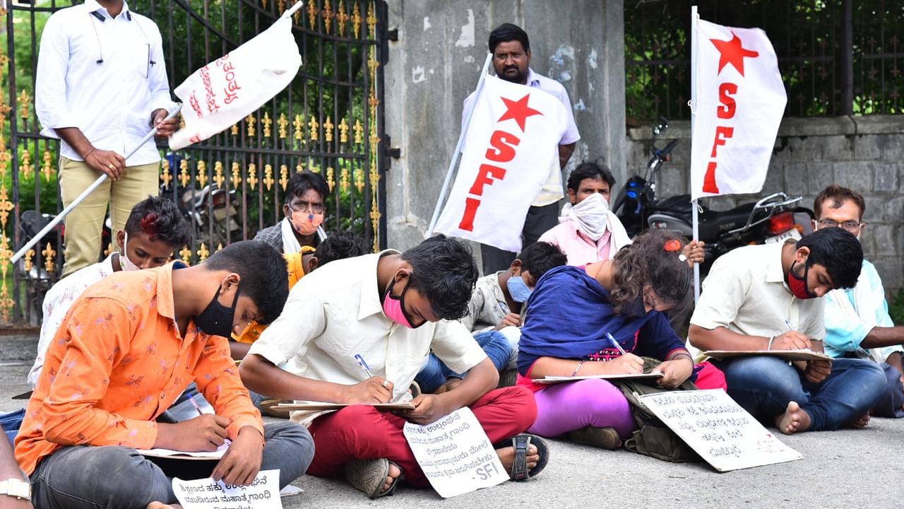 The aggrieved students on Monday registered their protest against their school and teachers by writing a mock exam on the road. Credit: DH Photo