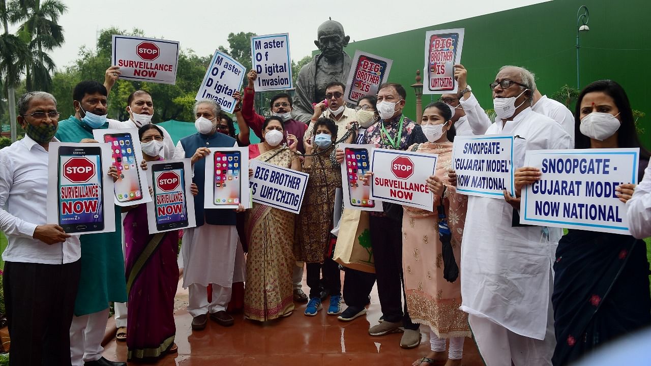 TMC MPs display placards as they stage a protest over the issue of surveillance during the Monsoon Session of Parliament. Credit: PTI Photo