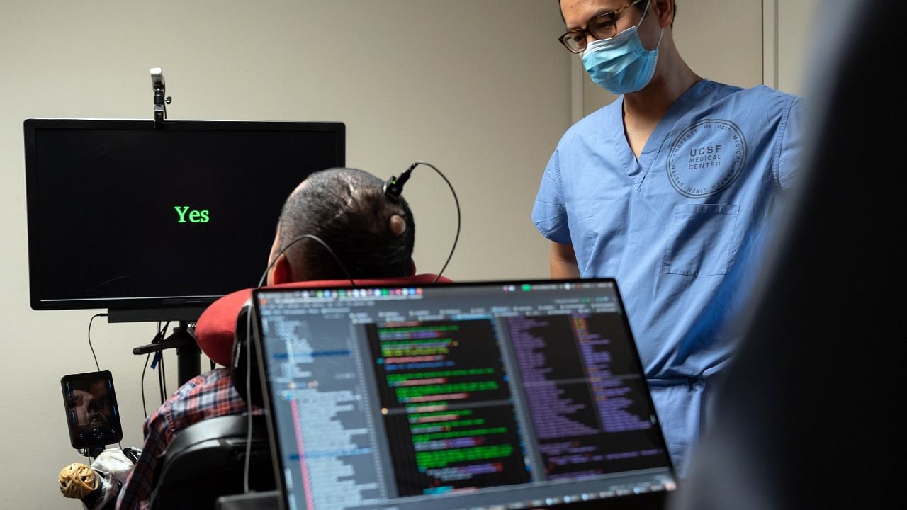 Dr Eddie Chang, a neurosurgeon at the University of California, San Francisco Medical School helps Pancho, a man paralyzed since age 20, speak through an implant in his brain that connects to a computer program. Credit: INYT Photo