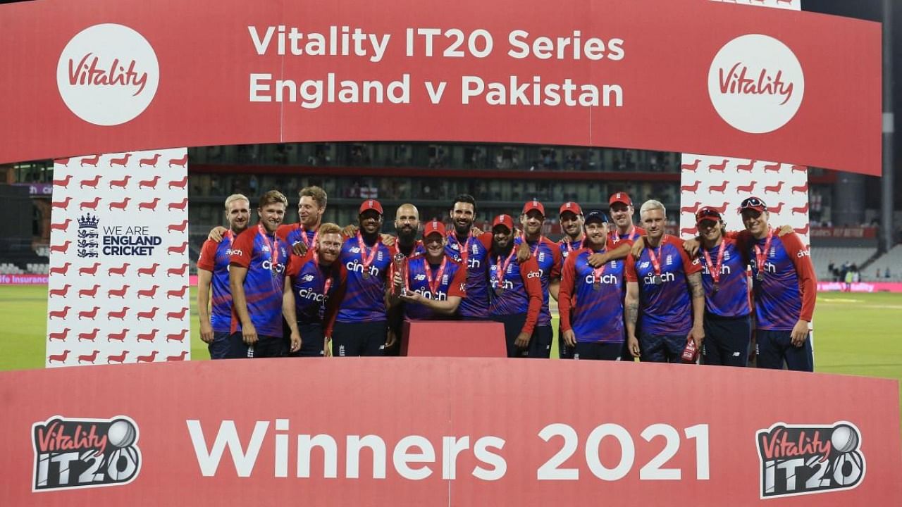 England's Captain Eoin Morgan (C), with teammates, raises the winner's trophy following the third T20 international cricket match between England and Pakistan at Old Trafford Cricket Ground in Manchester, northwest England. Credit: AFP Photo