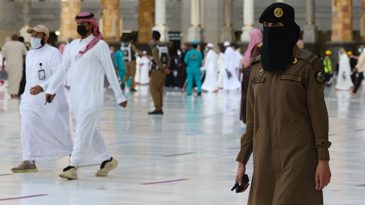 A Saudi ploicewoman stands guard as worshippers arrive at the Kaaba, Islam's holiest shrine, at the Grand mosque in the holy Saudi city of Mecca, on the first day of the al-Adha feast celebrated by Muslims worldwide. Credit: AFP Photo