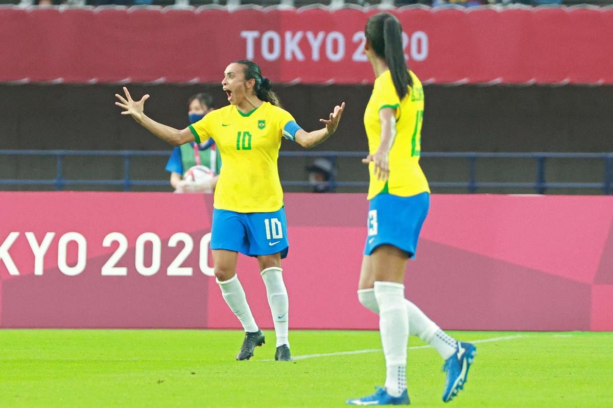 Brazil's midfielder Marta (L) celebrates after scoring her second goal, team's third, during the Tokyo 2020 Olympic Games women's group F first round football match between China and Brazil at the Miyagi Stadium in Miyagi. Credit: AFP Photo