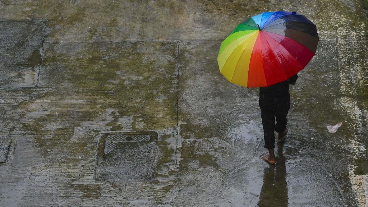 A man walks under an umbrella during a downpour in Mumbai. Credit: AFP Photo