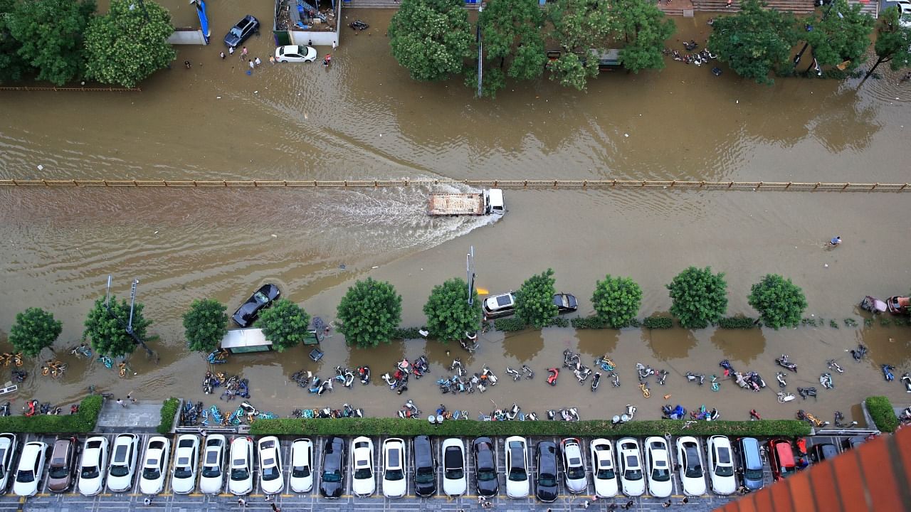 A truck travels on a flooded road after heavy rainfall in Zhengzhou, Henan province, China July 21, 2021. Picture taken July 21, 2021. Credit: China Daily via Reuters Photo