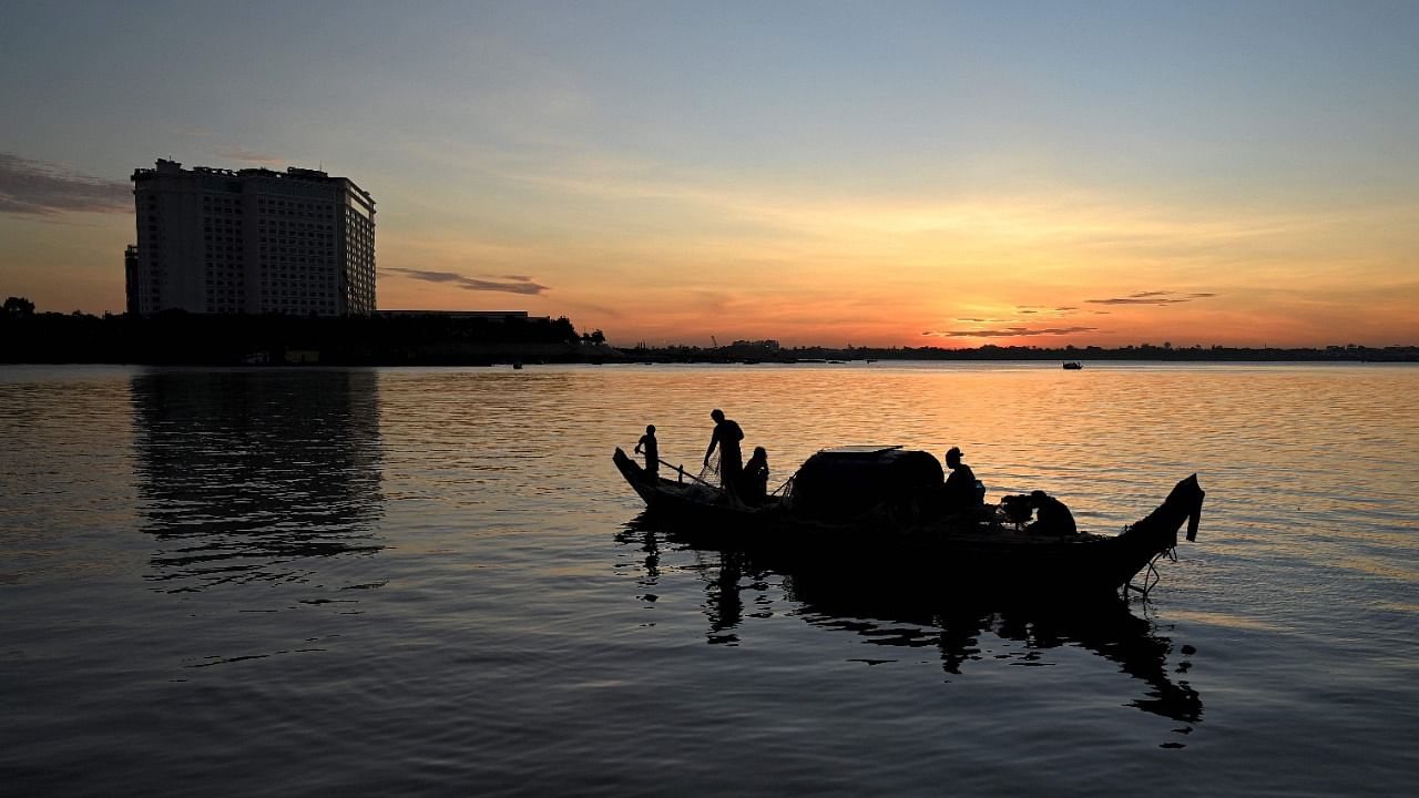 A fisherman sorts out a net on a fishing boat in the Mekong River in Phnom Penh. Credit: AFP File Photo
