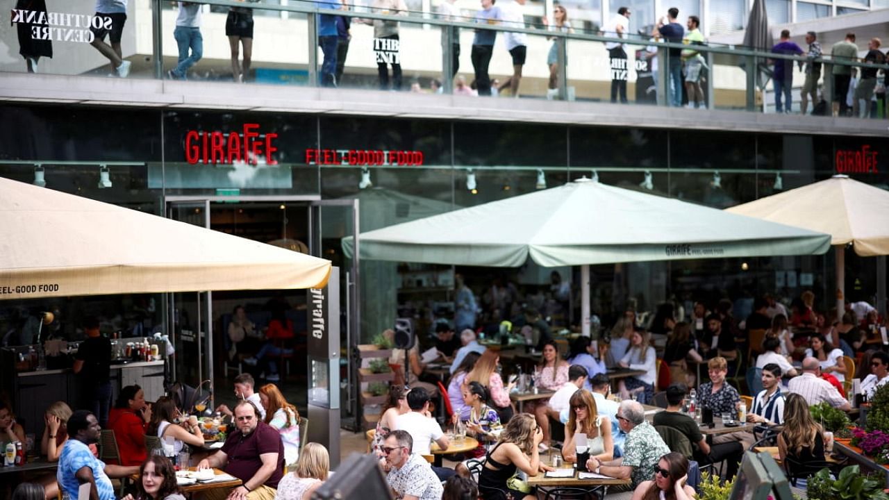 People sit at an outdoor restaurant on the South Bank during sunny weather, amid the coronavirus disease outbreak, in London. Credit: Reuters Photo