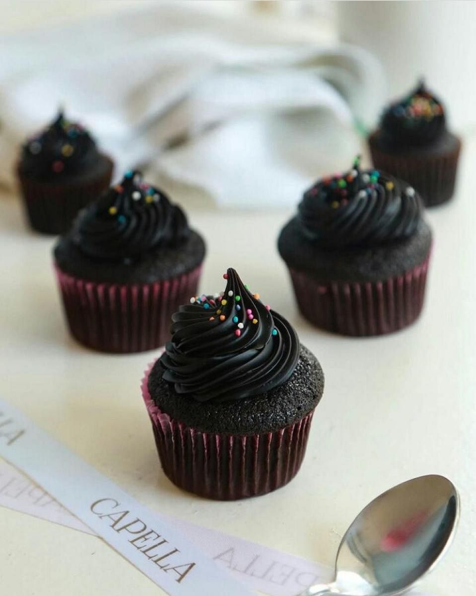 Cup chocolate cake topped with chocolate ganache frosting.