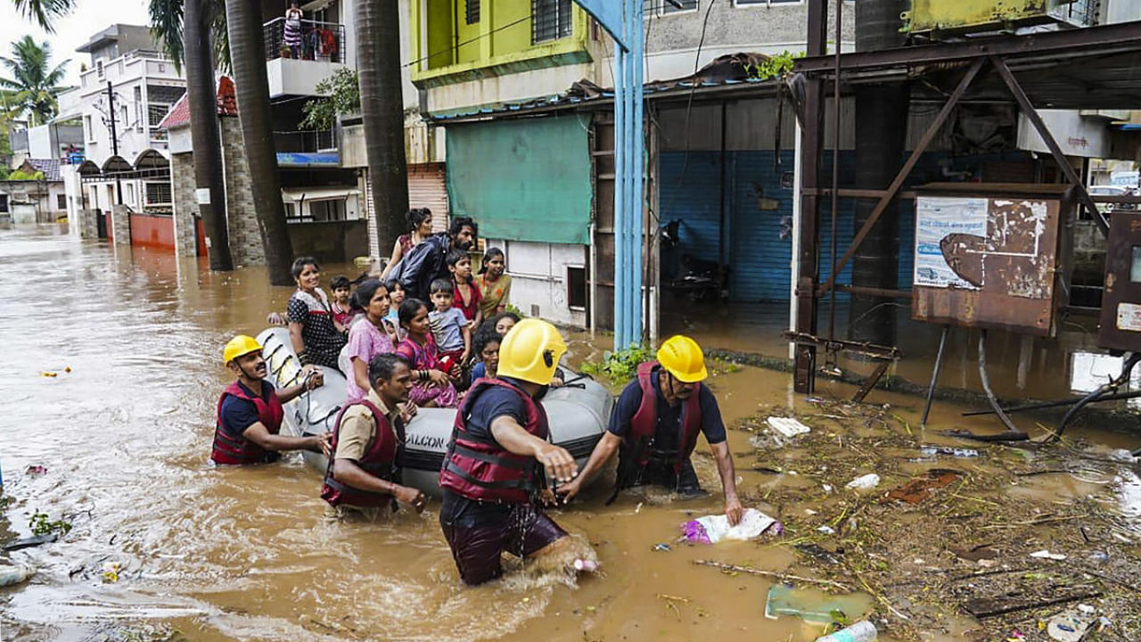Municipal Corporation firefighters during a rescue operation after heavy rain in Kolhapur. Credit: PTI Photo