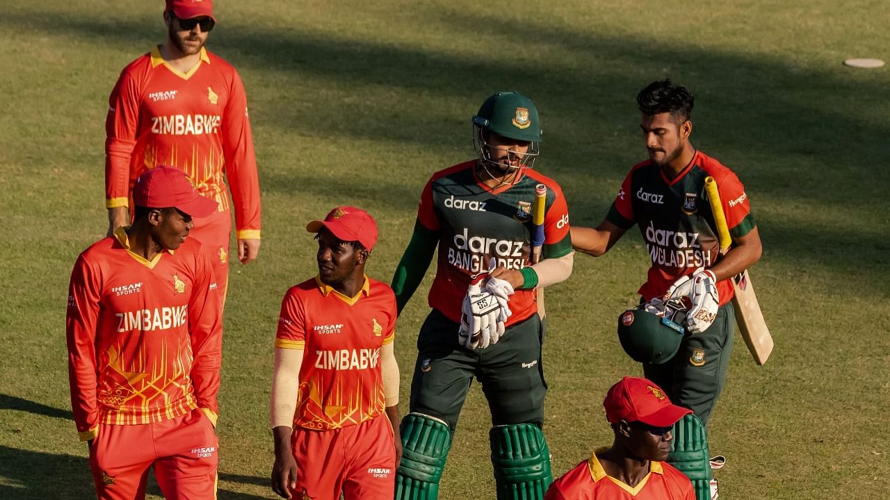 Bangladesh's batsman Nurul Hasan (C) and teammate Mohammad Naim(R) walk back to the pavilion with Zimbabwean fielders after victory in the first Twenty20 international cricket match between Zimbabwe and Bangladesh at The Harare Sports Club in Harare. Credit: AFP Photo
