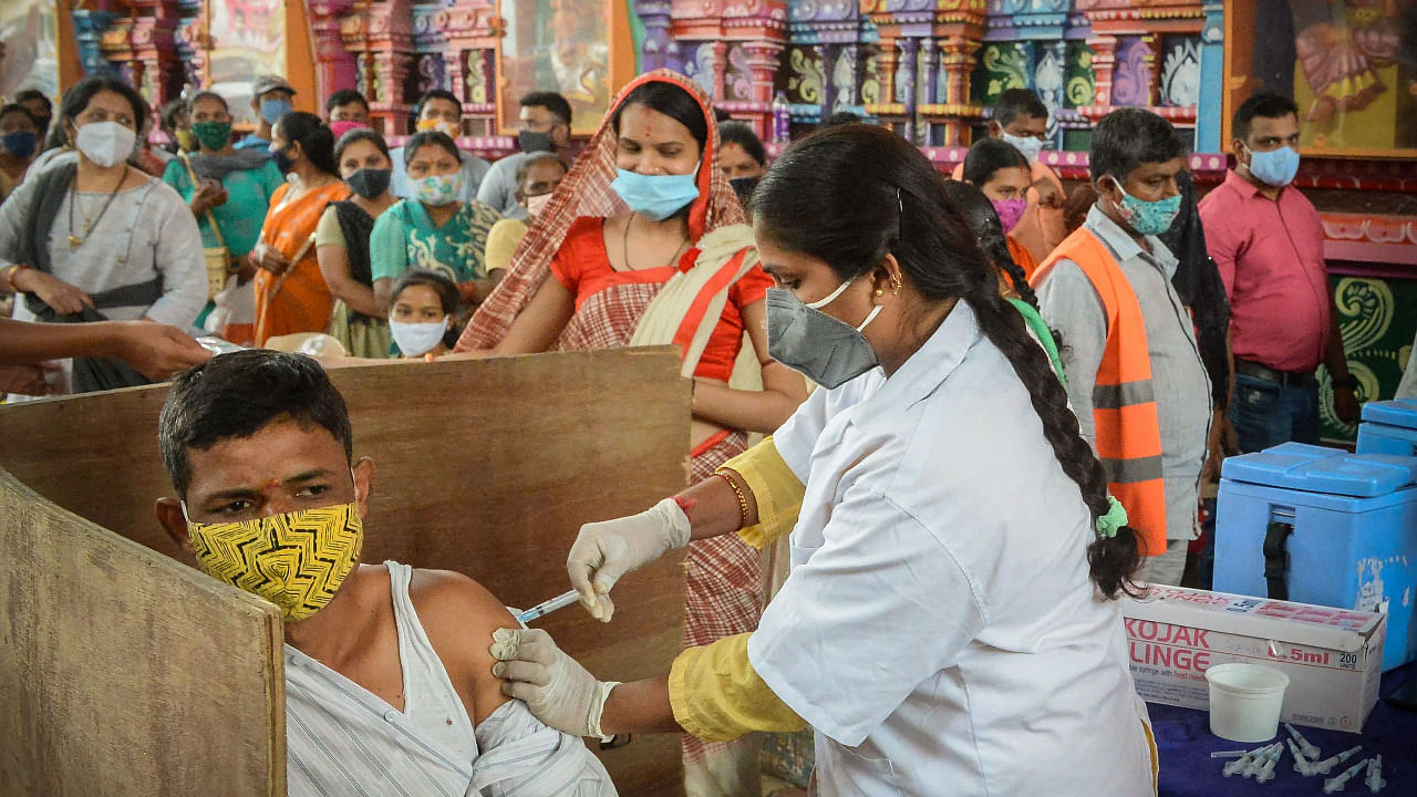 A health worker inoculates a man with a dose of the Covishield vaccine in Hyderabad. Credit: AFP Photo