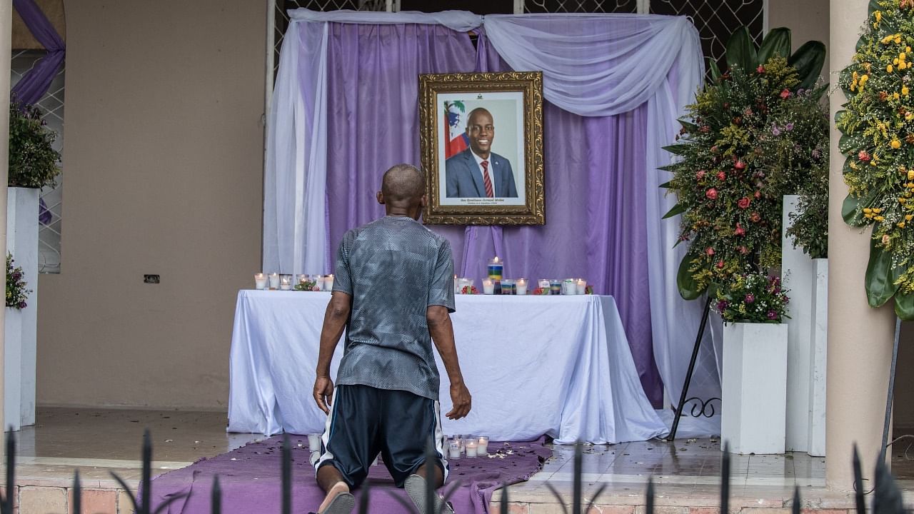 A man prays in front of a memorial for President Jovenel Moise in Haiti. Credit: AFP Photo
