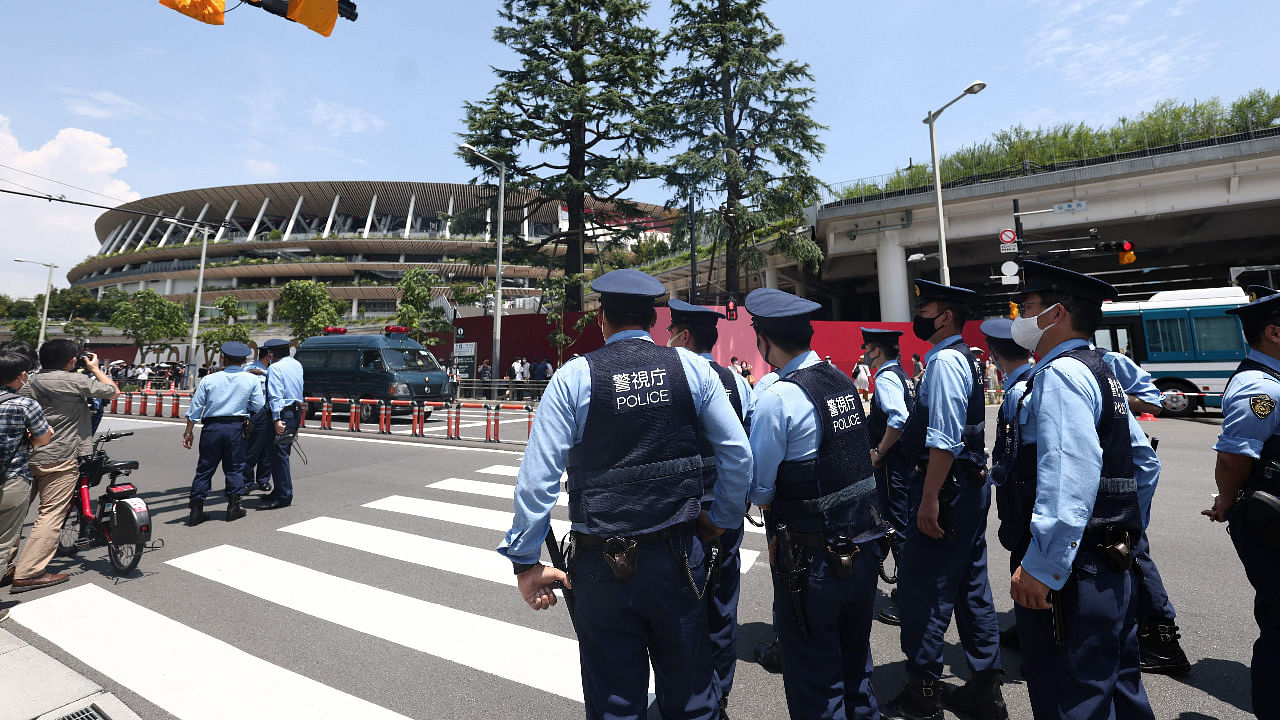 Police gather to manage the crowd before a performance by Blue Impulse, Japan's Air Self Defense Force (JASDF) aerobatic display team, in Tokyo on July 23, 2021, ahead of the opening ceremony of the 2020 Tokyo Olympic Games. Credit: AFP Photo