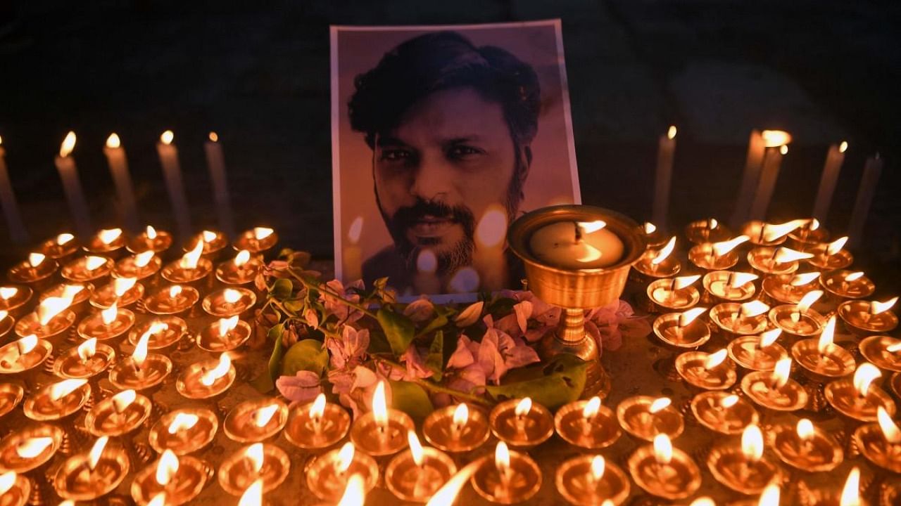 Photographers pay homage to Reuters journalist Danish Siddiqui in front of his portrait at Swayambhunath Stupa in Kathmandu. Credit: AFP Photo