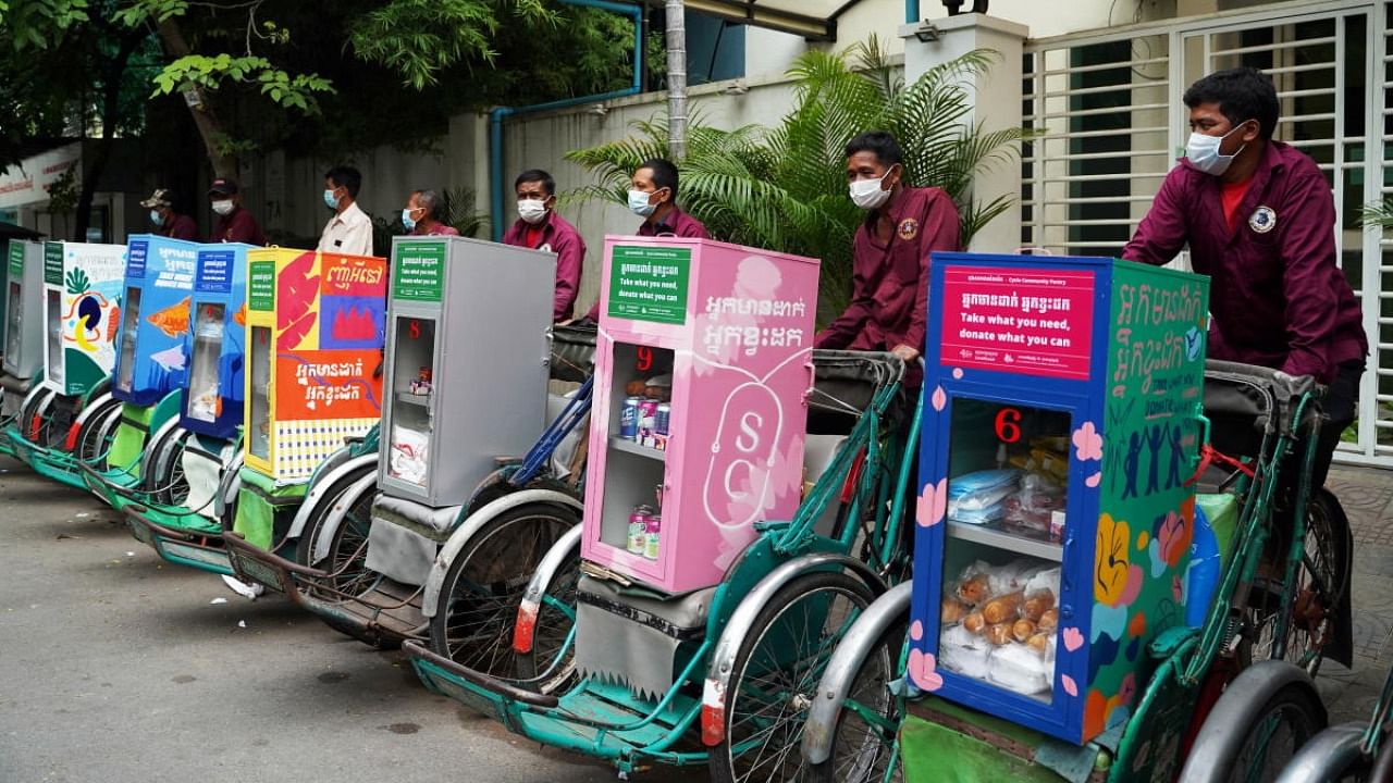 Cyclo drivers prepare to share donated food and supplies from a cyclo community pantry with people working along the streets during the coronavirus outbreak in Phnom Penh, Cambodia, July 19, 2021. Credit: Reuters Photo
