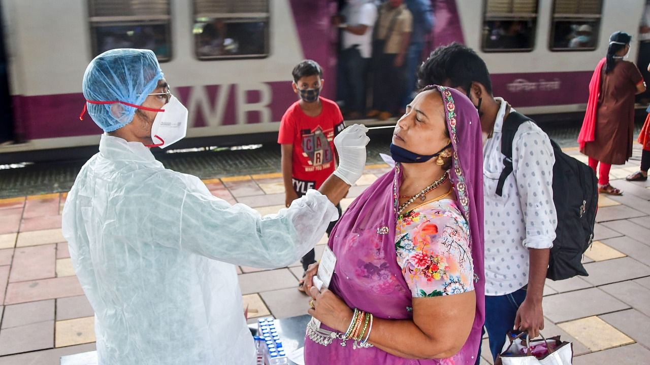 A BMC health worker collects swab samples of a passenger for Covid-19 test, at Dadar station, in Mumbai, Thursday, July 22, 2021. Credit: PTI Photo