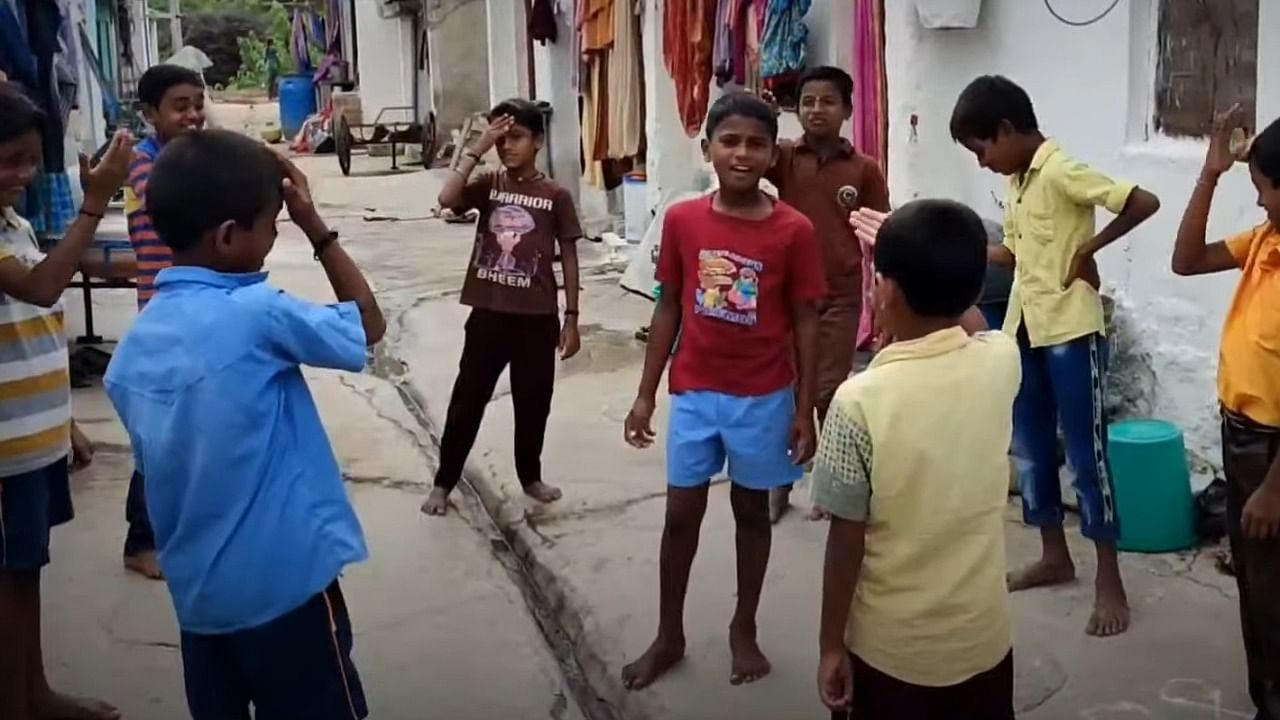 Basavaraj Pujar (C) in the music video for the song 'Geleyera Jodi Aatilla, Shaalyaga Teacher Paatilla'. Credit: Screengrab via Youtube