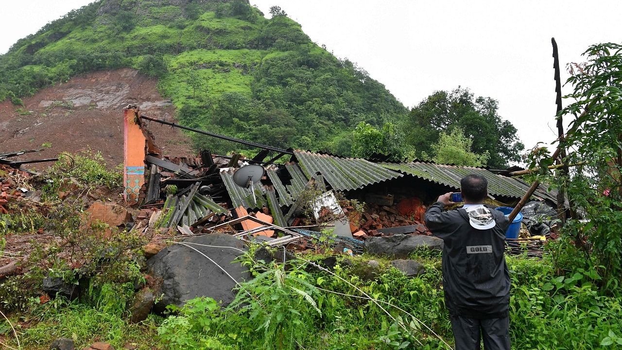 A man takes pictures of a landslide at Taliye, about 22 km from Mahad city. Credit: AFP Photo