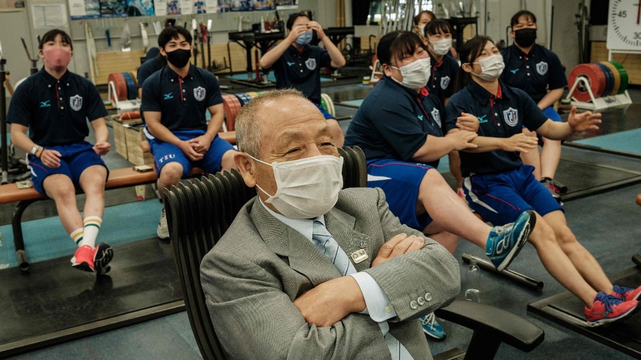 Yoshinobu Miyake (C), 81, two time Olympic Champion of weightlifting, watches the match of his niece Hiromi Miyake competing in the weightlifting women 49kg, during the Tokyo 2020 Olympic Games. Credit: AFP Photo