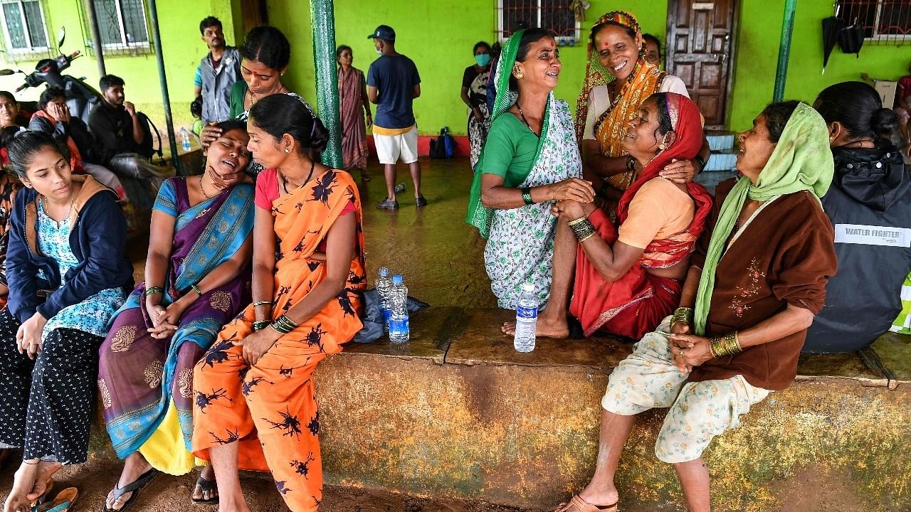 Villagers console a woman (2R) who lost a relative following a landslide at Taliye, about 22 km from Mahad city. Credit: AFP Photo