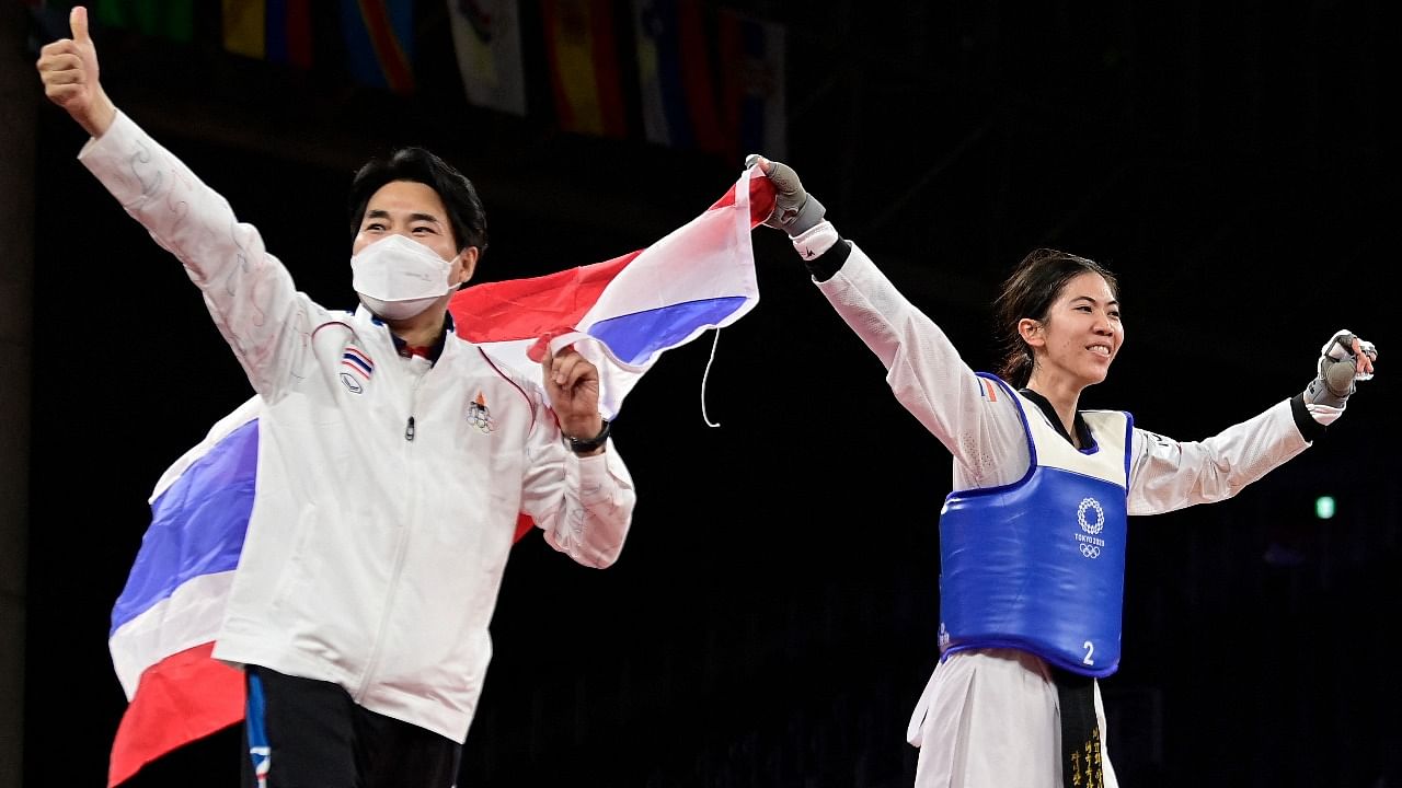 Thailand's Panipak Wongpattanakit and her coach celebrates winning against Spain's Adriana Cerezo Iglesias (Red)the taekwondo women's -49kg gold medal bout during the Tokyo 2020 Olympic Games at the Makuhari Messe Hall. Credit: AFP Photo