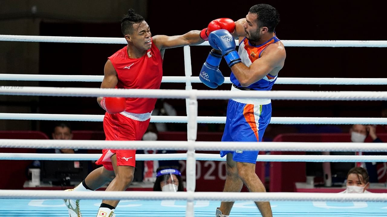 Japan's Sewonrets Quincy Mensah Okazawa, right, exchanges punches with India's Vikas Krishan during their men's welterweight 69-kg boxing match at the 2020 Summer Olympics. Credit: AP/PTI Photo
