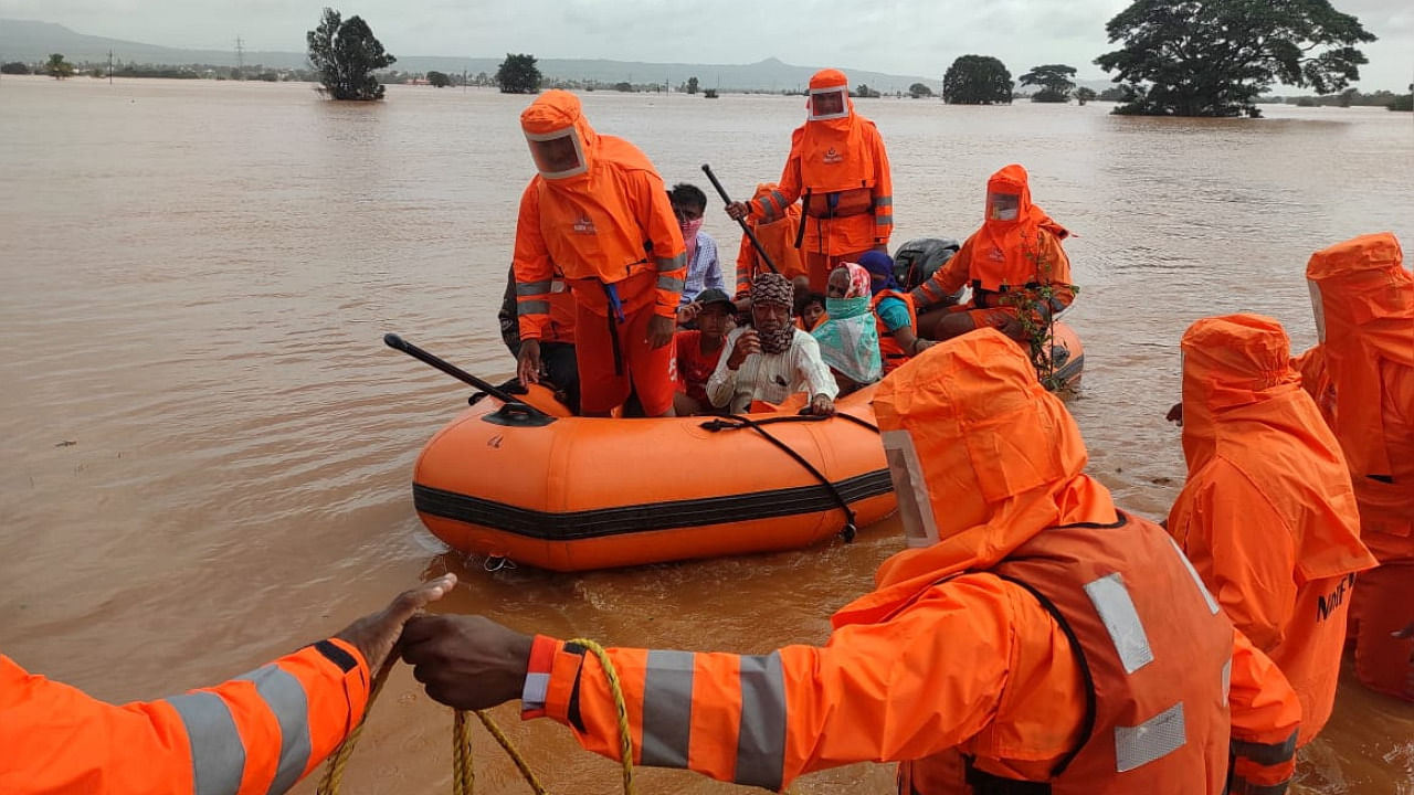 Members of National Disaster Response Force (NDRF) evacuate people from a flooded area to safer places in Balinge village. Credit: Reuters Photo