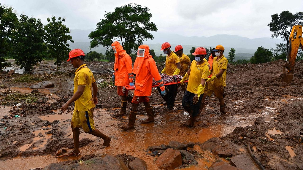 Target Disaster Response Force (TDRF) personnel carry the body of a victim at the site of a landslide at Taliye. Credit: AFP Photo