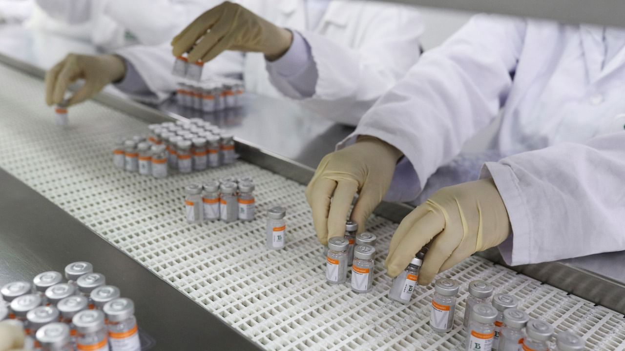 Workers pick up vials containing CoronaVac, Sinovac's Covid-19 vaccine. Credit: Reuters File Photo