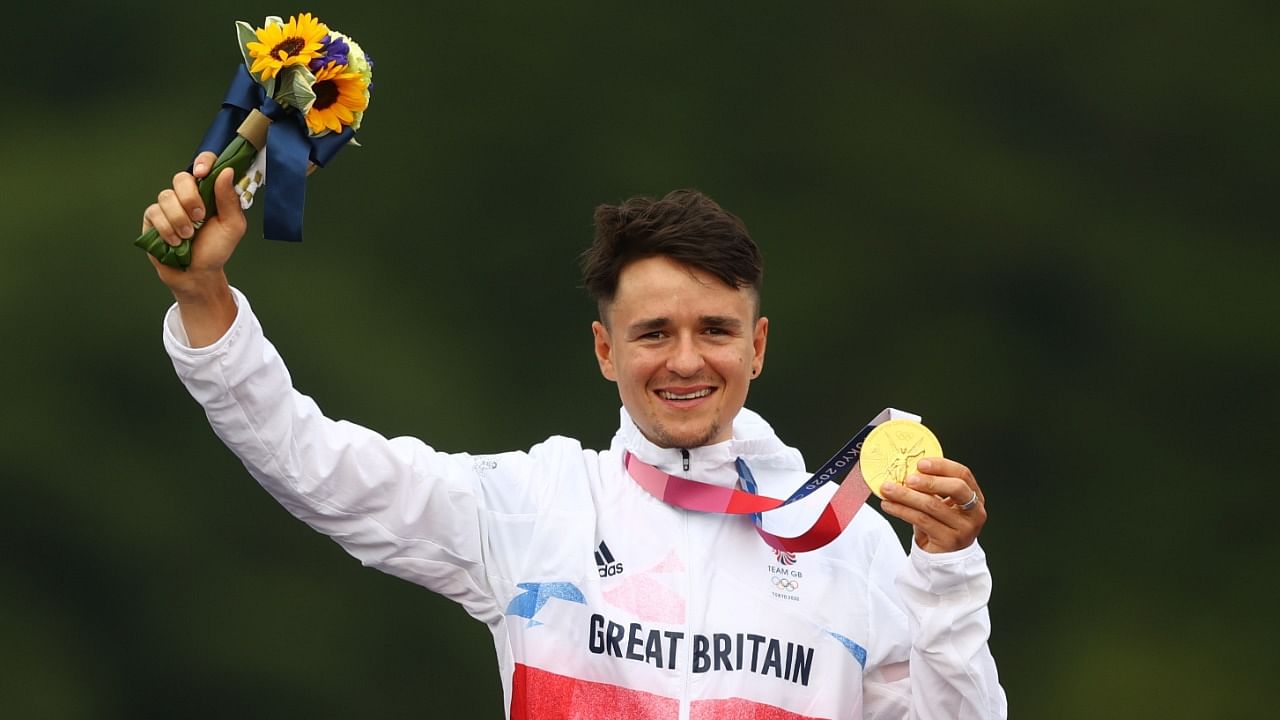 Gold medallist Tom Pidcock of Britain celebrates on the podium. Credit: Reuters Photo
