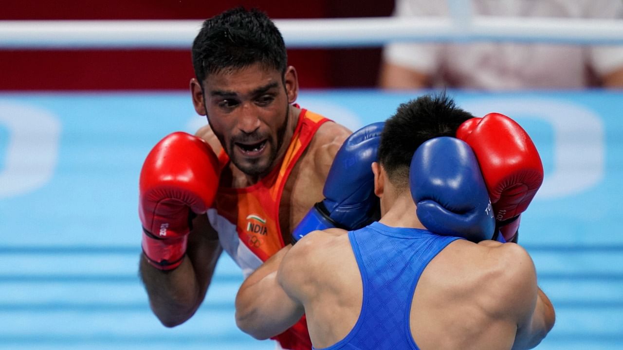 India's Ashish Kumar, left, exchanges punches with China's Tuoheta Erbieke during their men's middleweight 75-kg boxing match at the 2020 Summer Olympics, Monday, July 26, 2021, in Tokyo, Japan. Credit: AP/PTI Photo