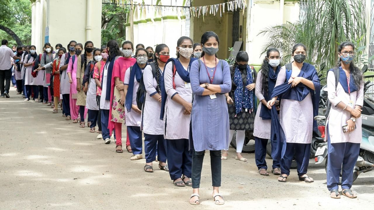 Students form a queue before attending classes at Maharani's Science College for Women in Mysuru on Monday. Credit: DH Photo