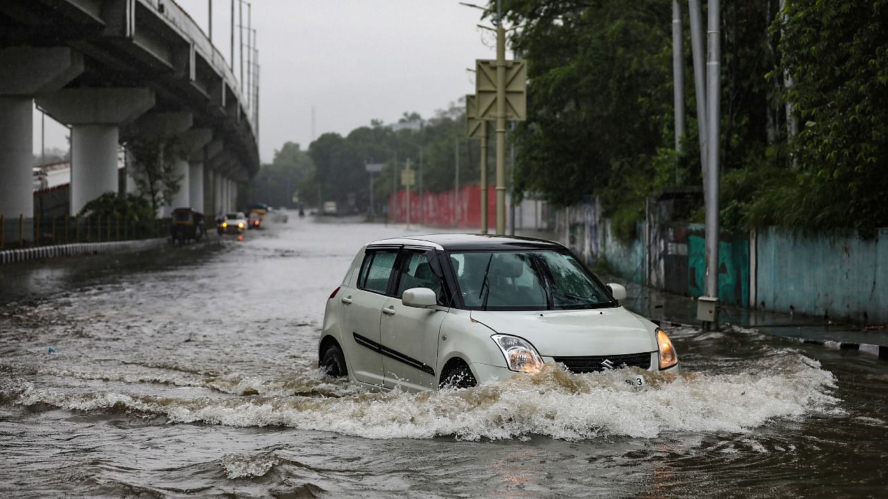 A vehicle wades through a waterlogged street at Green belt park during heavy rains in Jammu, Monday, July 26, 2021. Credit: PTI Photo